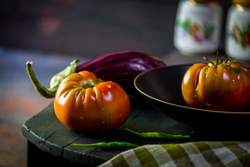 Preparation with vegetables on dark ground in the kitchen