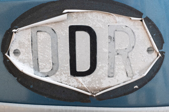 Alter DDR - Heckaufkleber an einem Fahrzeug, bei das das D hervorgehoben ist.