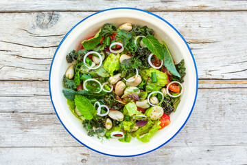 A healthy and delicious salad made from fresh vegetable leaves and broad beans. Vegetarian food.
