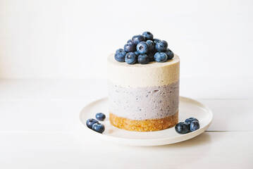 Vegan vanilla blueberry cheesecake against white background.