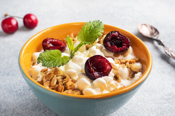 Grain curd muesli with fresh cherries on a plate. Concept healthy Breakfast with cottage cheese and berries.