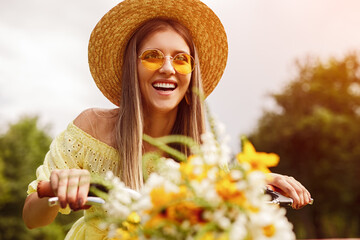 Happy woman riding bicycle with flowers