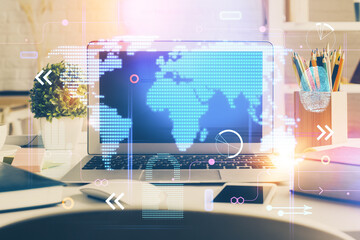 Double exposure of desktop with computer and world map hologram. International data network concept.