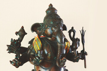 Bronze figurine of the indian god Ganesha isolated on beige background.
