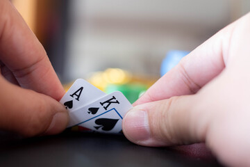 The Casino table with cards showing black jack on hand and blurred casino chips and Gold coin  in the background