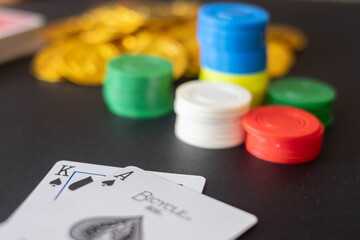 The Casino table with cards showing black jack on table and blurred casino chips and Gold coin  in the background
