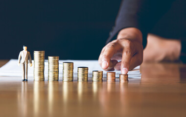 The fingers of man who climbed the coin heights were placed on a wooden table,The concept of...