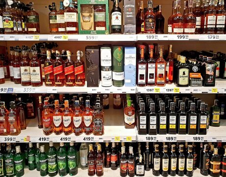 PRAGUE, CZECH REPUBLIC - AUGUST 07, 2020: Selection of various spirit bottles tagged with discount price tags on shelf in Tesco grocery store. Tesco was founded in 1919 by Jack Cohen.