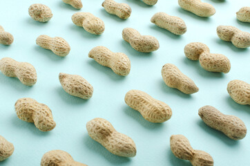 Lines of peanuts on the brigh blue background.Peanut as a background