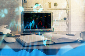 Financial chart drawing and table with computer on background. Multi exposure. Concept of international markets.