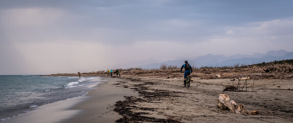 Mountain biker on the beach in Tuscany