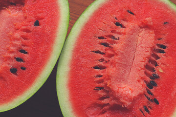 A watermelon cut into two halves on the table. Close-up.