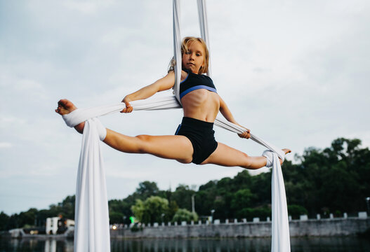 Two cute and handsome little girls doing front splits on violet