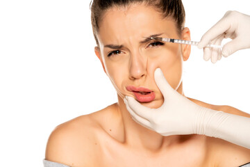 Portrait of a young frightened woman on a face filler injection procedure