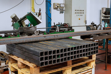 Pieces of metal profile of the same length. Cutting steel profiles on a band saw in production.