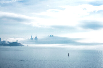 The beautiful beach and bay with thick mist blow from the sea to the land.