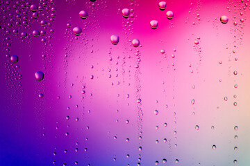 Water droplets on glass surface. Colorful blurred abstract of water drops texture on pink magenta background