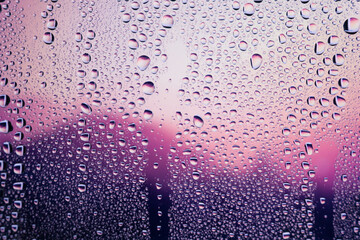Water droplets condensed on the glass surface in the evening. View through the window in the rainy season