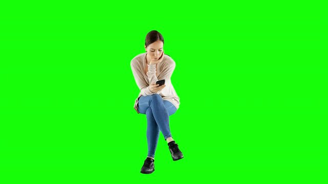 Woman Wearing a Knitted Kardigan Using a Smartphone While Sitting Green Screen