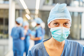 Fototapeta na wymiar Junge Frau als Chirurgin in blauer OP-Kleidung
