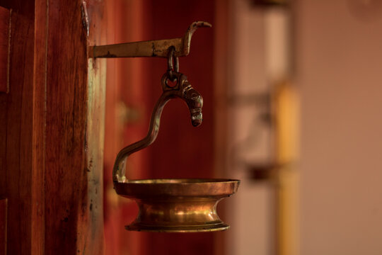 golden coloured copper and brass lantern used in indian temples
 