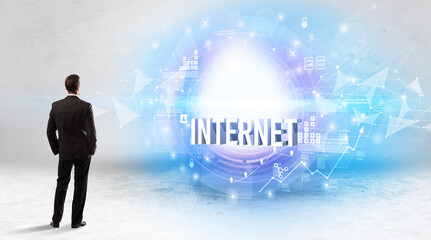 Rear view of a businessman standing in front of INTERNET inscription, modern technology concept