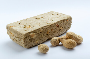Closeup of halva, unpeeled peanuts on the white background