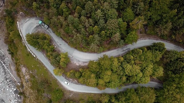 Aerial lock up shot of vehicle passing through the hairpin turns of curvy himalayan road in manali