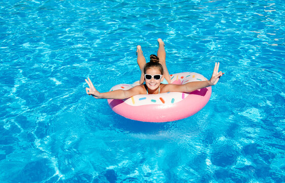 Cute smiling little girl in swimming pool with rubber ring
