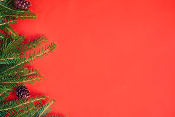 Christmas background with xmas tree on red canvas background. Merry christmas card. Winter holiday theme. Happy New Year. Space for text. christmas backdrop top view. Flat lay.