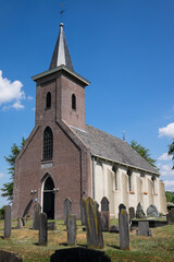 Fototapeta na wymiar Bonifatius (Boniface) church in the Frisian village Ter Idzard in the Netherlands with a cemetery around it