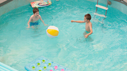 Two boys playing in the swimming pool