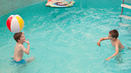 Two boys playing in the swimming pool
