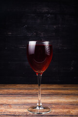 glass of red wine on wooden background
