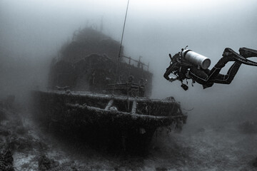 Scuba diver underwater with shipwreck 