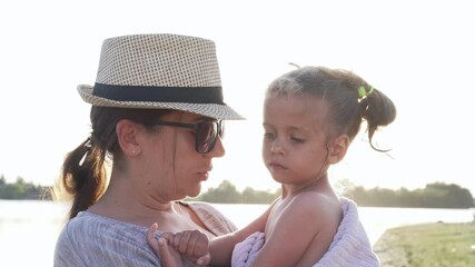 Mother hugging kisses little daughter wipes towel beach outdoor sunny day Positive human emotions, feelings, emotions. Portrait of happy family on the vacation