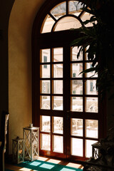Wooden brown door with glass overlooking the balcony with tables and chairs for relaxation.