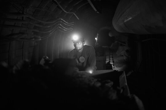 Silhouette of a working miner in a mine