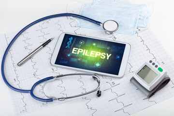 Tablet pc and medical stuff with EPILEPSY inscription, prevention concept