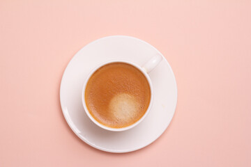black coffee in a cup on a pink background.