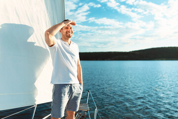 Fototapeta premium Happy Man Sailing On Yacht Standing On Deck Outside