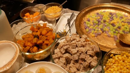 Top view of selection of various platters with delicious asian food and spices on a street market stall in Bangkok, Thailand.