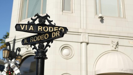 Fototapeta na wymiar World famous Rodeo Drive symbol, Cross Street Sign, Intersection in Beverly Hills. Touristic Los Angeles, California, USA. Rich wealthy life consumerism, Luxury brands and high-class stores concept.