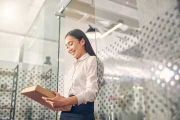 Cute international female person standing in the office