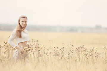 happy girl in autumn field with spikelets landscape / adult young girl portrait, summer look, nature
