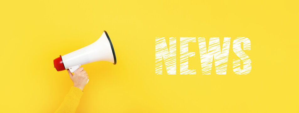 megaphone in hand and inscription news on a yellow background, news concept, panoramic image