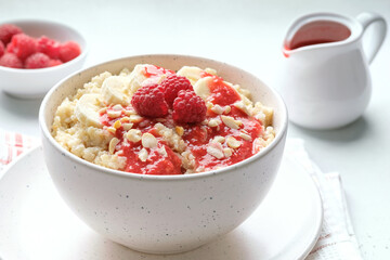 Healthy breakfast - quinoa porridge with banana, raspberry sauce and peanuts