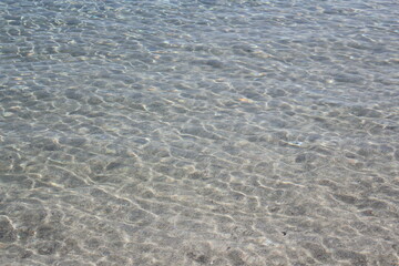 clear shimmering water at a sunny turquoise colored beach 