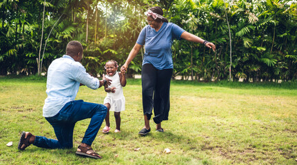 Portrait of enjoy happy love black family african american father and mother with little african girl child smiling running and having fun moments good time in summer park at home