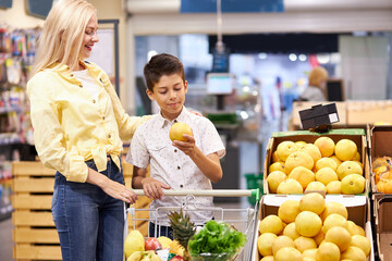 now people can shop freely, adult blonde lady and kid boy in supermarket, talk. people don't keep distance, after quarantine